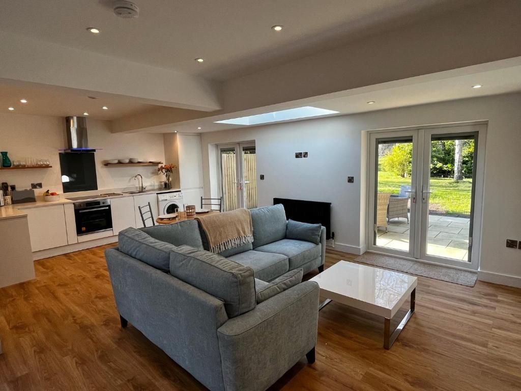 a living room with a couch and a table at Spinney on the Green in Woodhall Spa