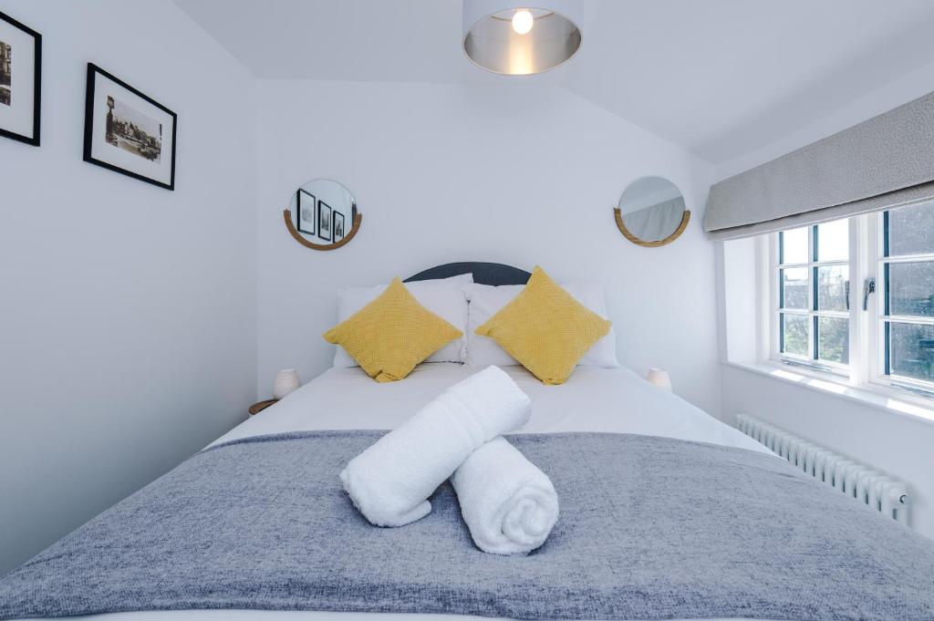 a bedroom with a bed with white sheets and yellow pillows at Stylish Home with Canal Views in Chester