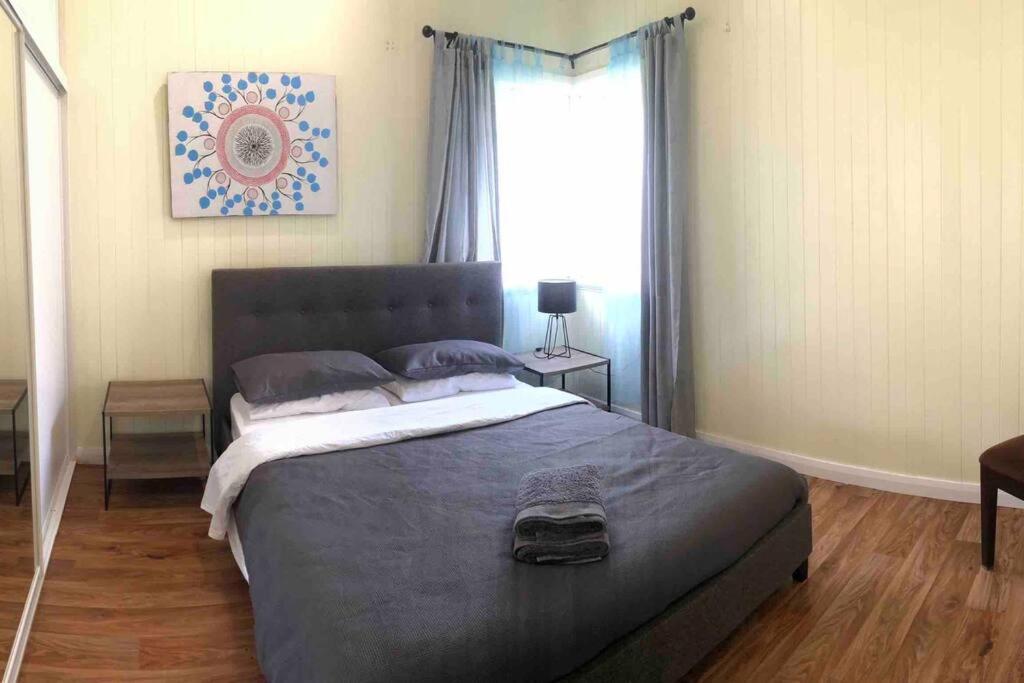 1 dormitorio con 1 cama grande en una habitación con ventana en Queenslander in the heart of Atherton - Spotless en Atherton