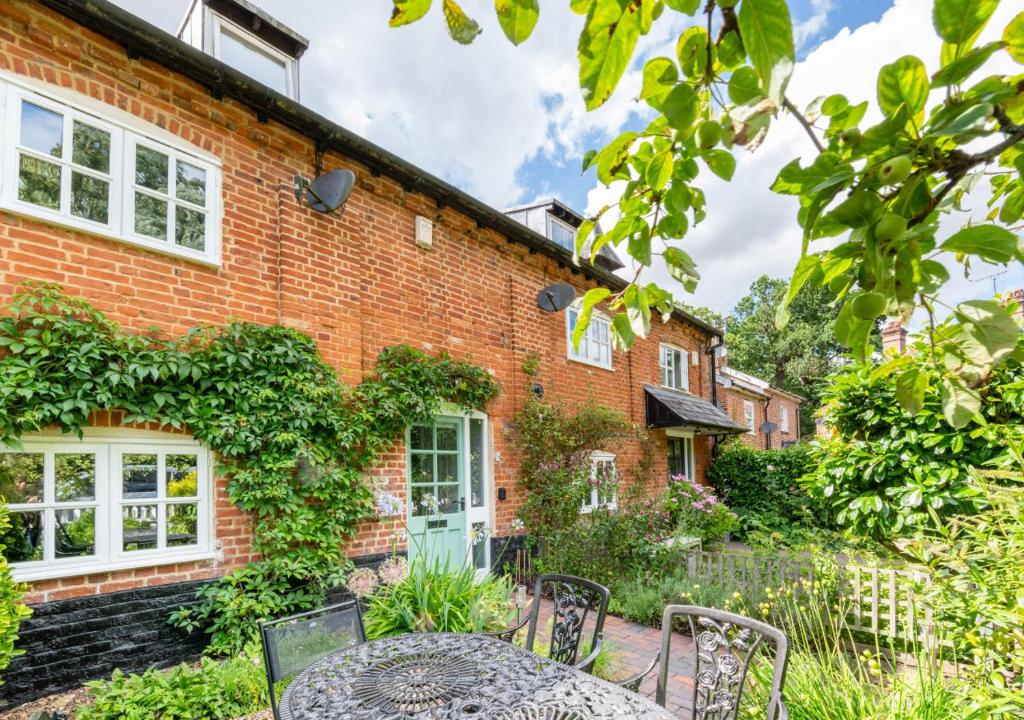 una casa de ladrillo con una mesa y sillas delante de ella en 5 River Lane, en Halesworth