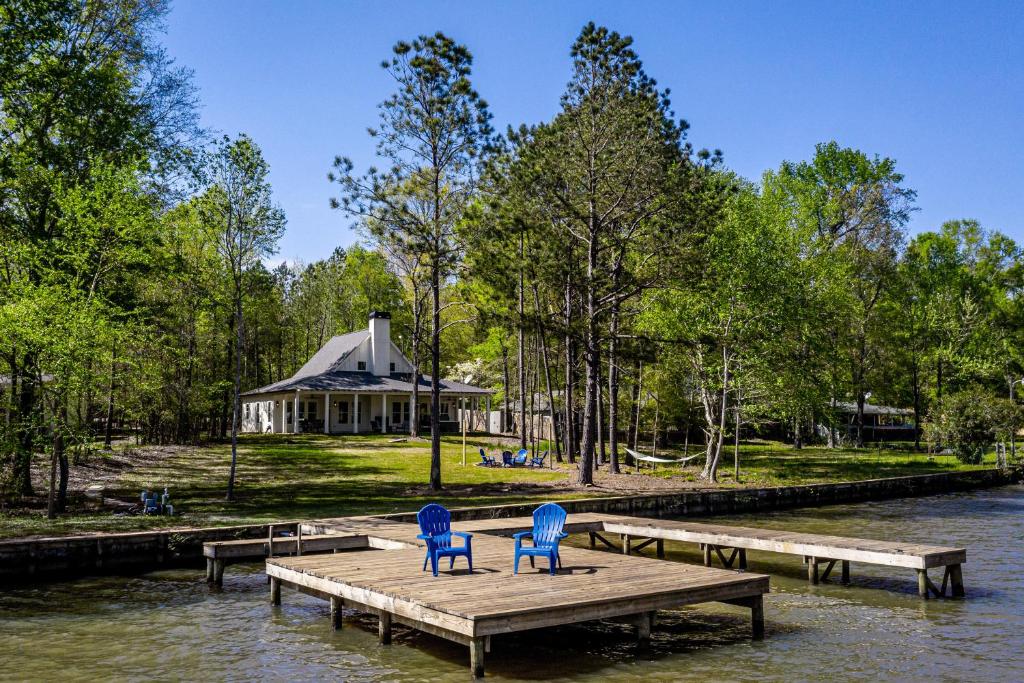 two blue chairs on a dock with a gazebo at Captain's Cove in Eatonton