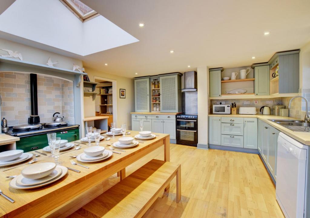 a kitchen with a wooden table with plates on it at 4 Doric Place in Woodbridge