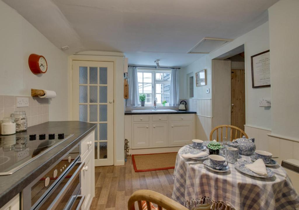 uma cozinha com uma mesa com uma toalha de mesa em 9 Gate Cottage em Long Melford