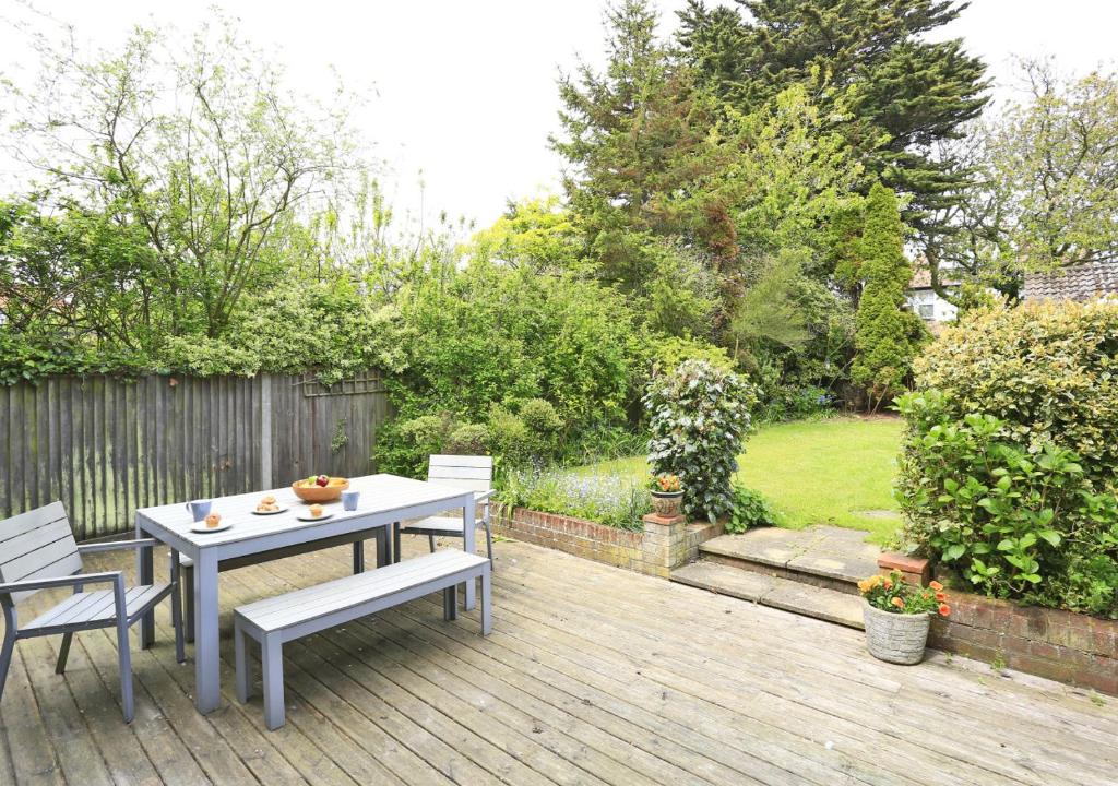 a patio with a table and chairs on a wooden deck at Arva in Southwold