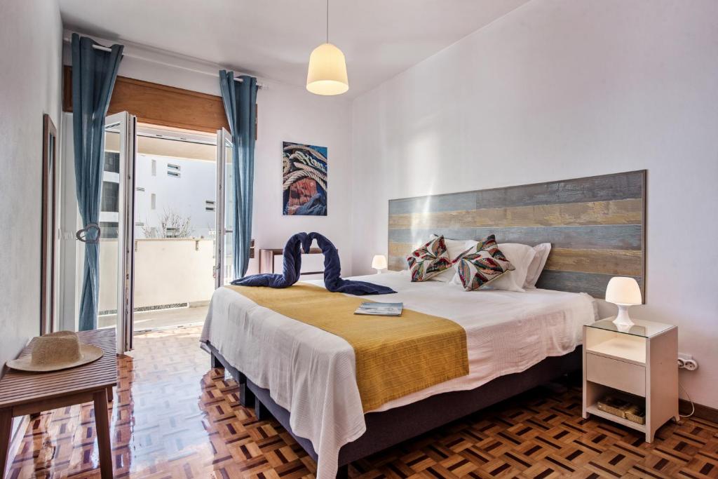 - une chambre avec un grand lit et une tête de lit en bois dans l'établissement Sea Star Apartments - Casa Verde e Casa Azul, à Armação de Pêra