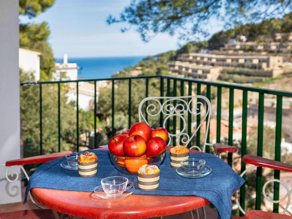 a table with a bowl of fruit on a balcony at Apartment S'Olivera-5 by Interhome in Begur