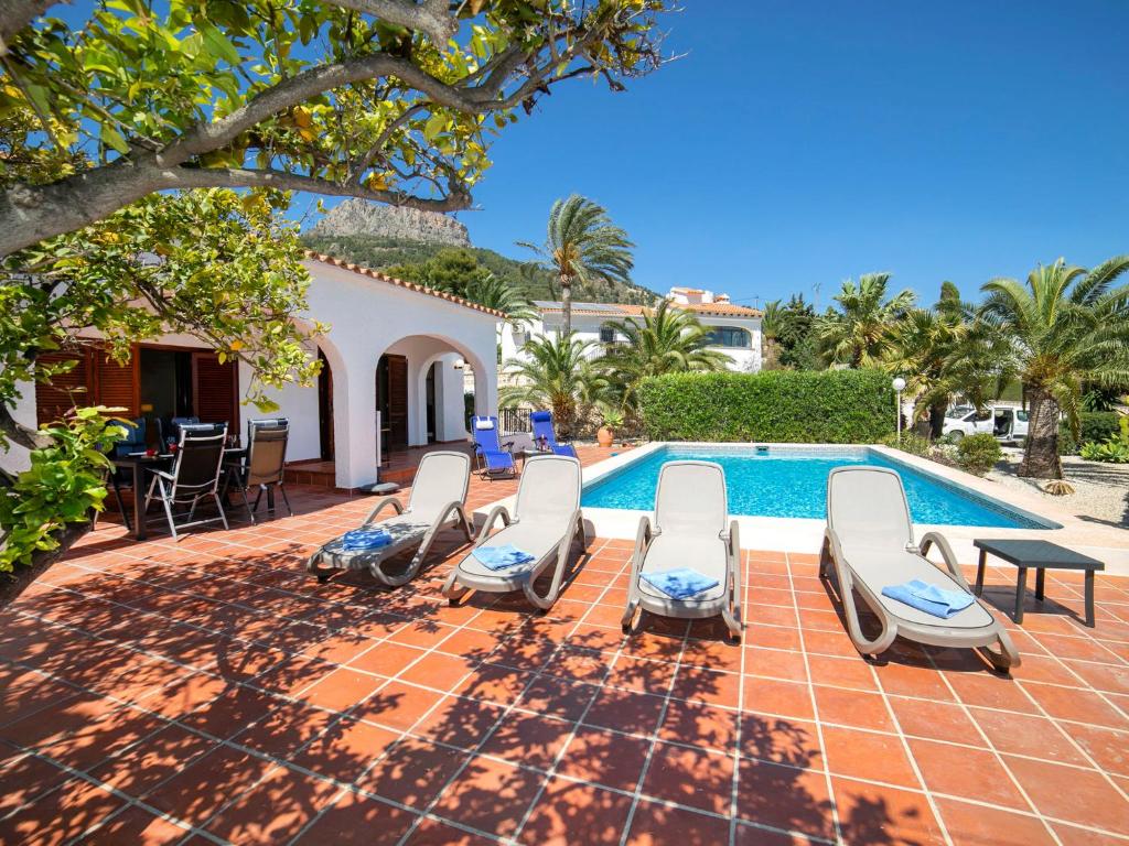 a villa with a swimming pool with chairs and a table at Holiday Home Cecile by Interhome in La Canuta