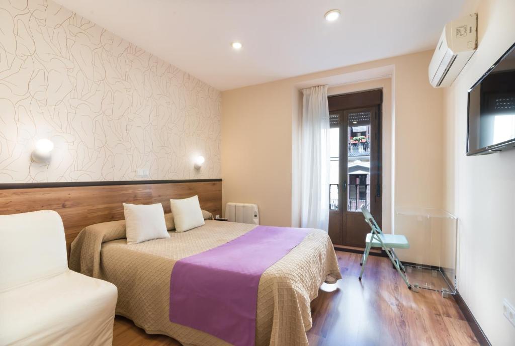 une chambre d'hôtel avec un lit et une chaise dans l'établissement Hostal Art Madrid, à Madrid