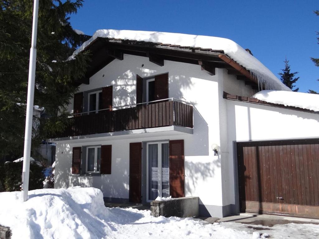 une maison blanche avec un balcon dans la neige dans l'établissement Apartment Chalet Eien by Interhome, à Engelberg