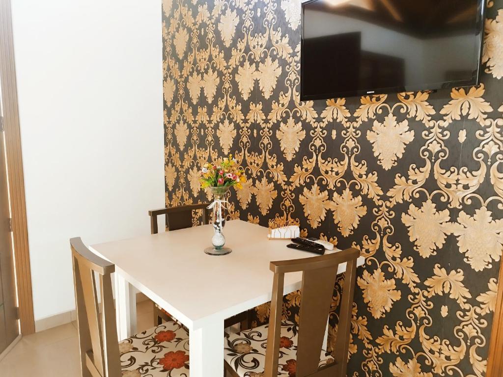 mesa con 2 sillas y TV en la pared en Pousada Estrela Do Luar, en Urubici