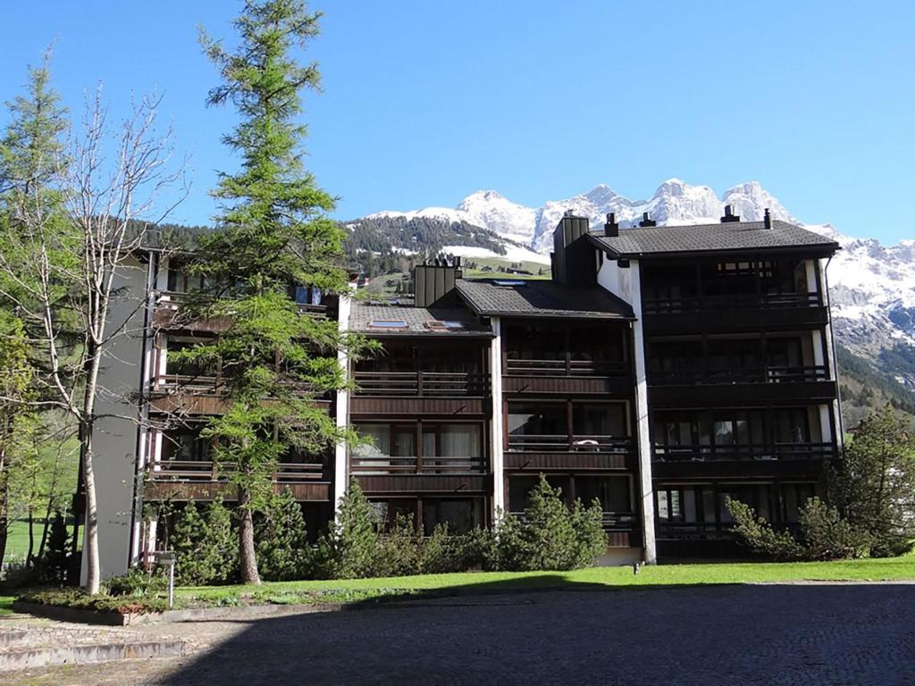 ein großes Gebäude mit Bergen im Hintergrund in der Unterkunft Apartment Am Dürrbach 5-517 by Interhome in Engelberg