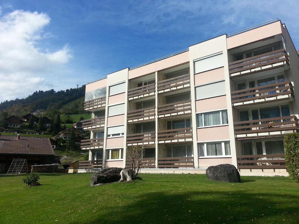 ein großes Gebäude mit einem grünen Feld davor in der Unterkunft Apartment Neuschwändi 66 by Interhome in Engelberg