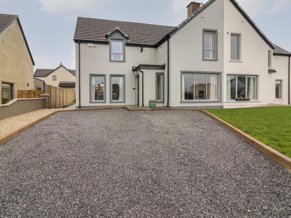 a house with a gravel driveway in front of it at 20 Lighthouse Village in Fenit