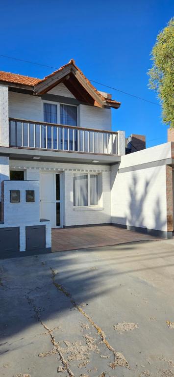 a white house with a porch and a driveway at Duplex de Playa in Playa Unión