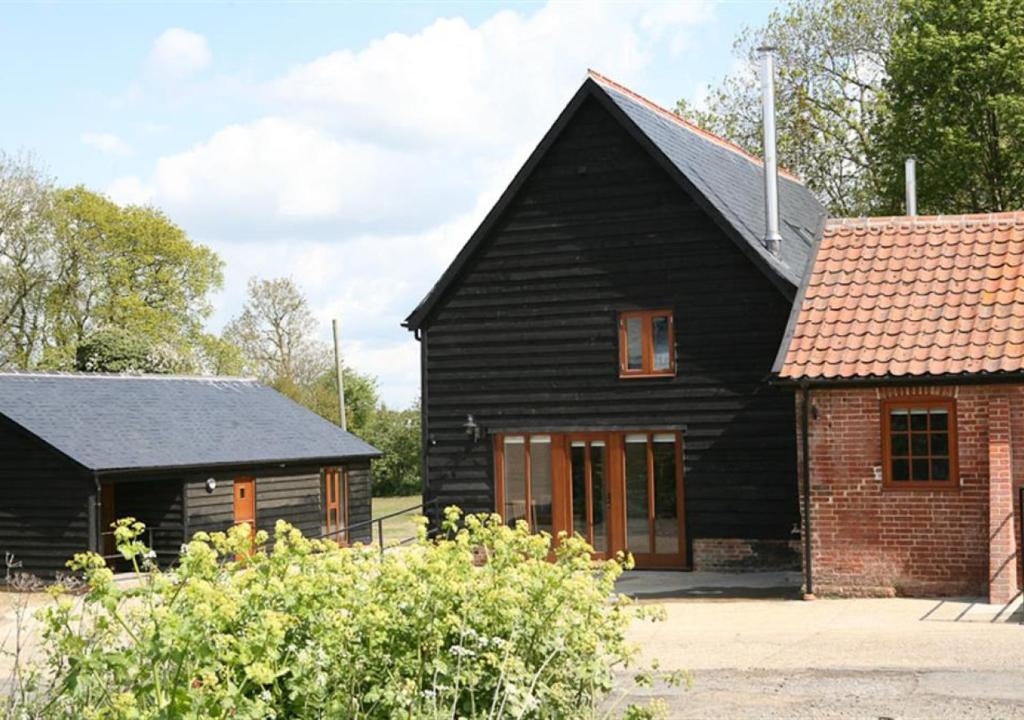 a black house with a red brick building at Christmas Cottage Sternfield in Friston