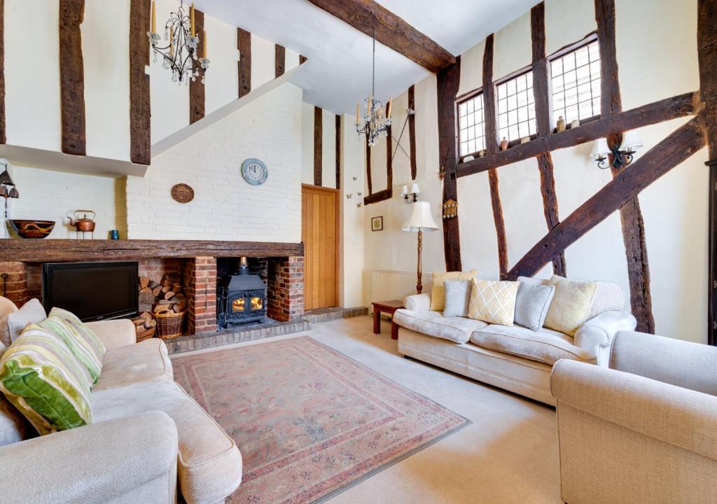 a living room with two couches and a fireplace at Clematis Cottage in Lavenham