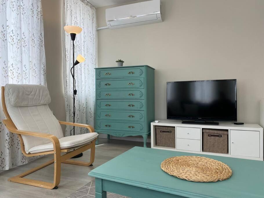ガブロヴォにあるAprilov Apartmentのリビングルーム(テレビ、椅子、テーブル付)