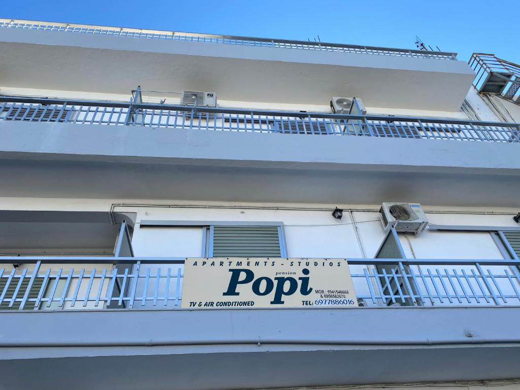 un edificio blanco con un cartel en el balcón en Popi Studios, en Cos