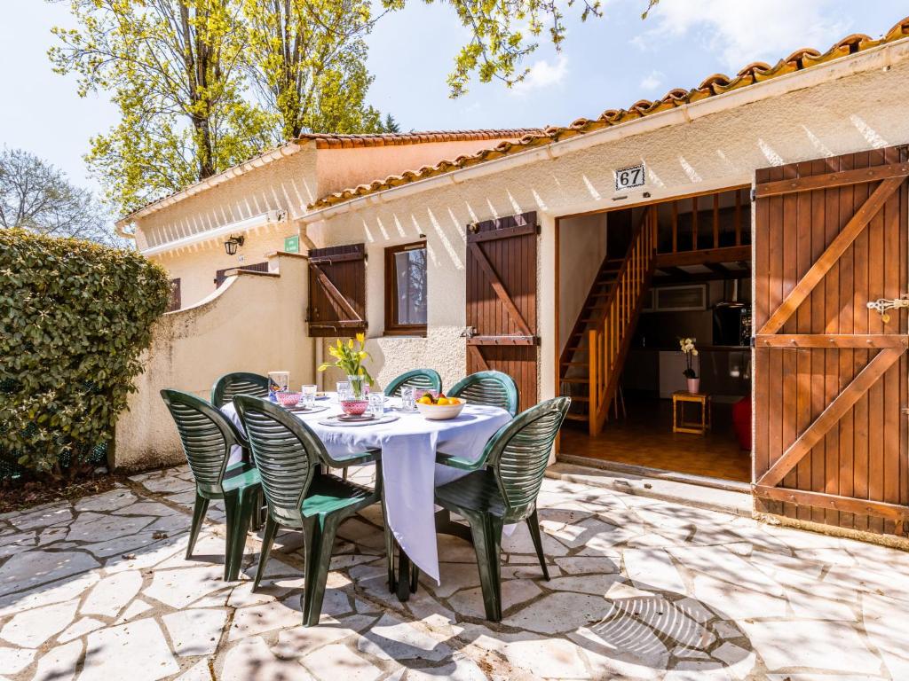 a table and chairs on a patio with a house at Holiday Home Les Maisons de l'Océan-1 by Interhome in Les Mathes