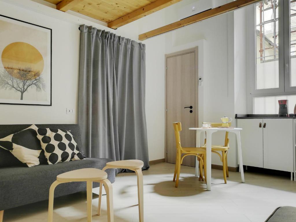 sala de estar con sofá, mesa y sillas en Bed & the City - mini loft urbano, en Turín