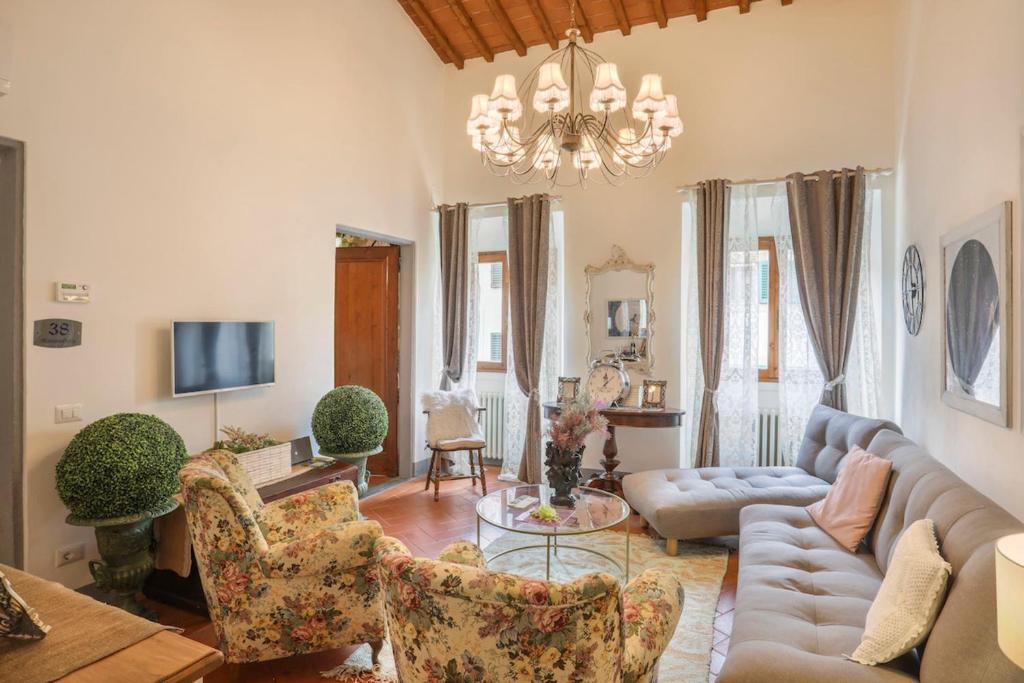 een woonkamer met een bank, stoelen en een kroonluchter bij SANGALLO Suite-Hosted by Sweetstay in Florence