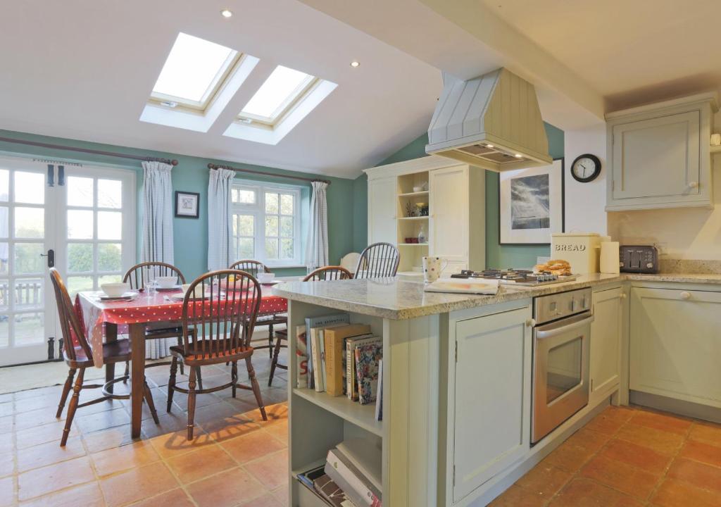 a kitchen and dining room with a table and chairs at Easter Cottage in Westleton