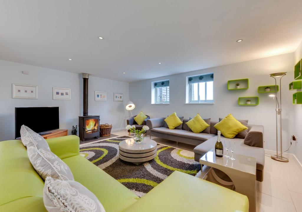 uma sala de estar com um sofá e uma lareira em East Barn Cottage em Aldringham