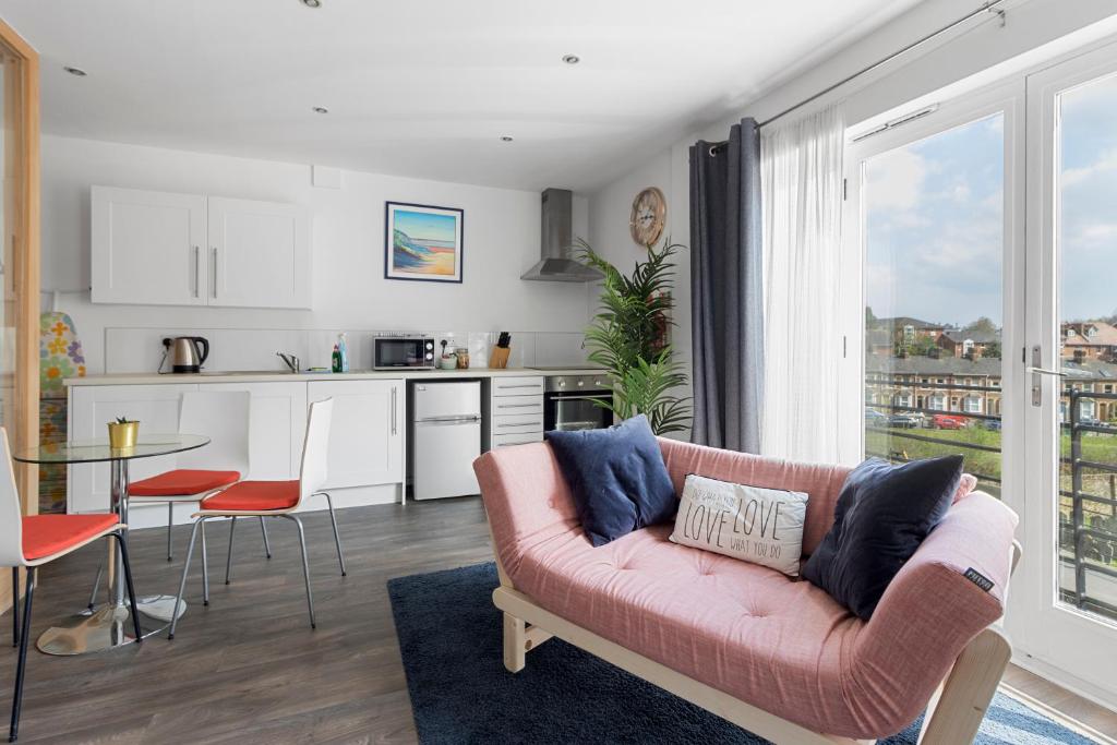 uma sala de estar com um sofá e uma cozinha em Exeter City Centre Apartments Eden Apartment em Exeter