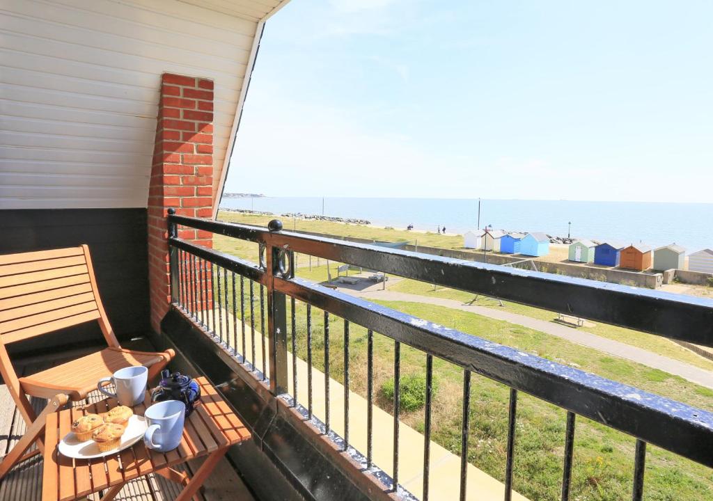 a balcony with a bench and a view of the ocean at Felsto Beach in Felixstowe