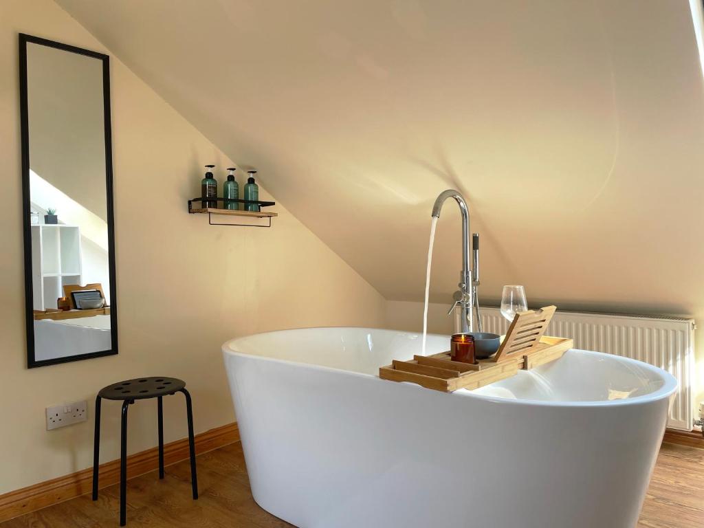 uma grande banheira branca num quarto com tecto em Mini-studio by HNFC Stays em South Shields