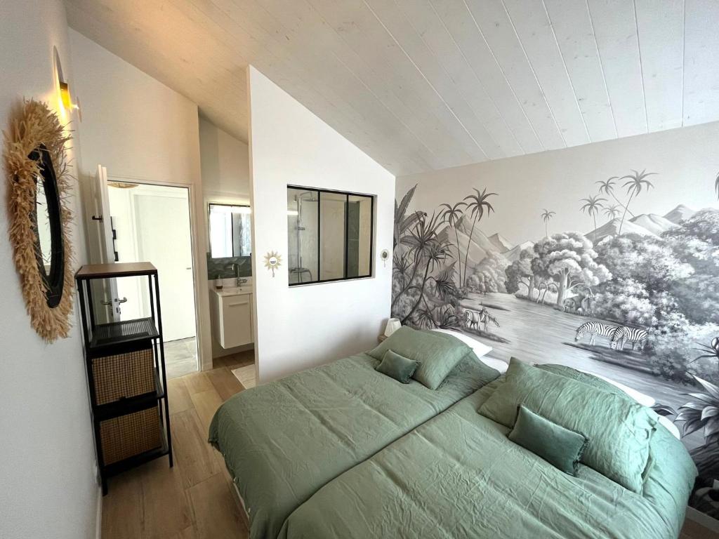 Un dormitorio con una cama verde y una pintura en la pared en La Maison de Lena 500m de la Plage en Barbâtre