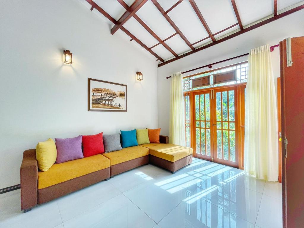 a living room with a couch with colorful pillows at Ceylon Serenity Villa in Beruwala