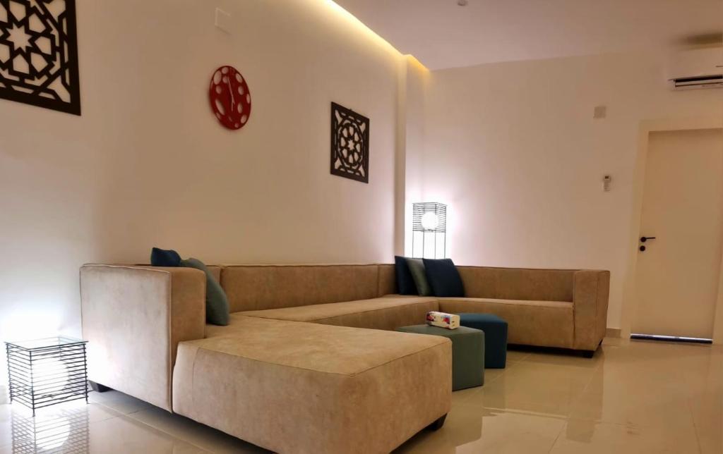 ein Wohnzimmer mit einem Sofa und einem Tisch in der Unterkunft Byblos Deluxe in Aqaba
