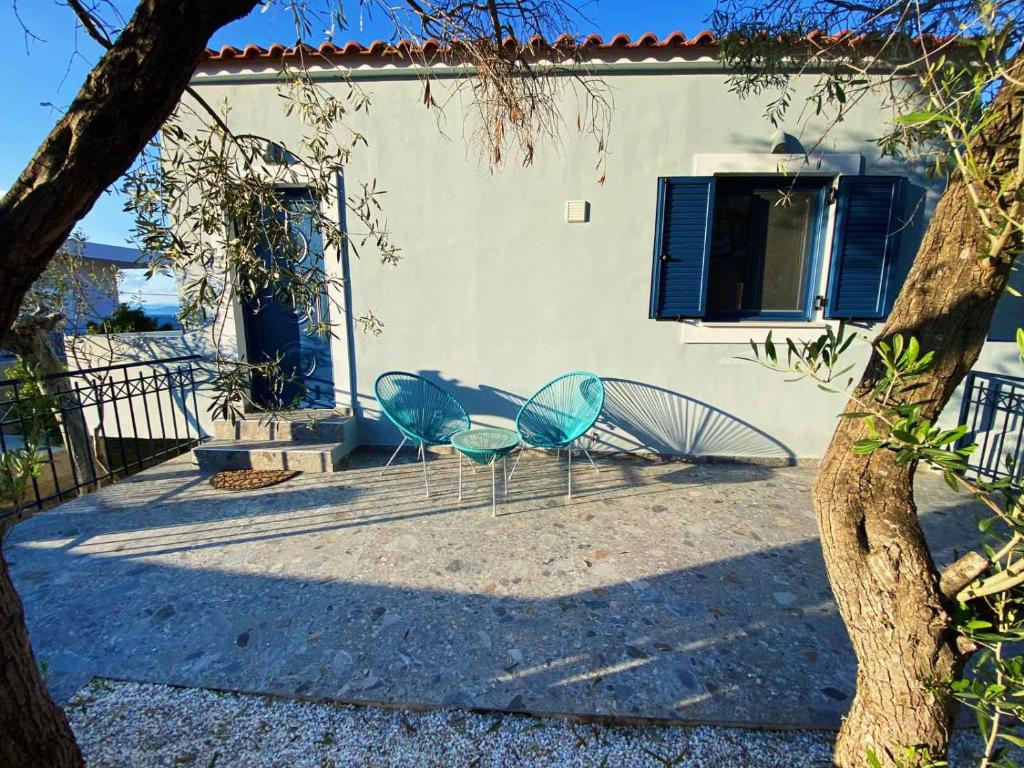 two blue chairs sitting in front of a building at The Dona House in Vaia
