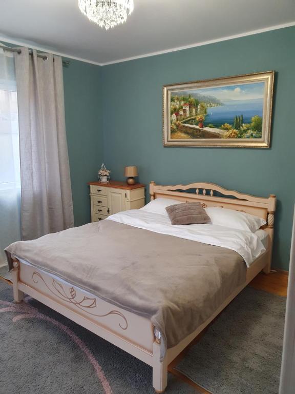 1 dormitorio con 1 cama con una pintura en la pared en Vila Sunset 2, en Galaţi