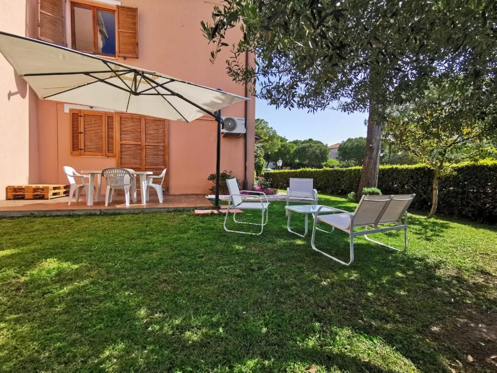 錫羅洛的住宿－N172 - Numana, meraviglioso trilocale con giardino，庭院里设有带椅子和遮阳伞的庭院。