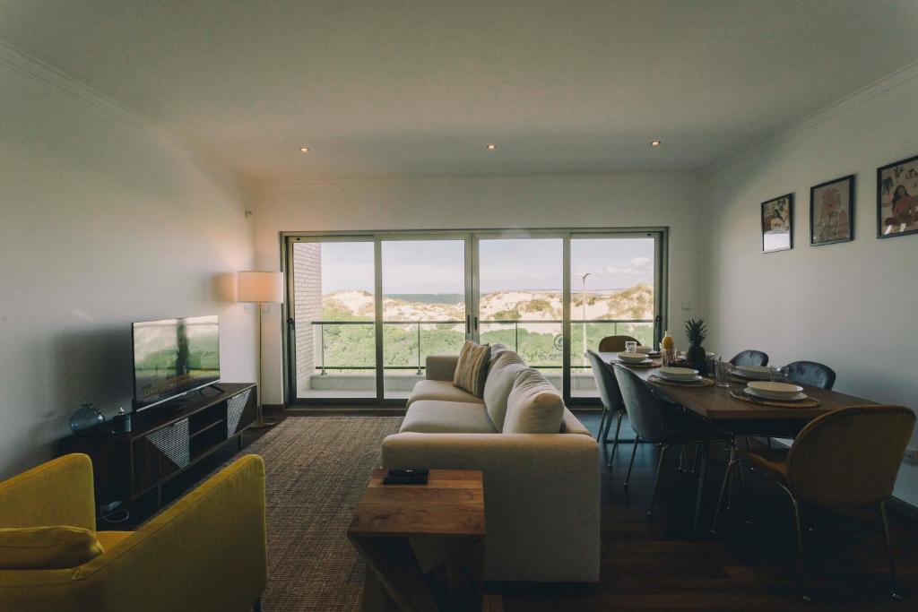 ein Wohnzimmer mit einem Sofa und einem Esstisch in der Unterkunft Best Houses 74 - SurfSide Lodge in Peniche