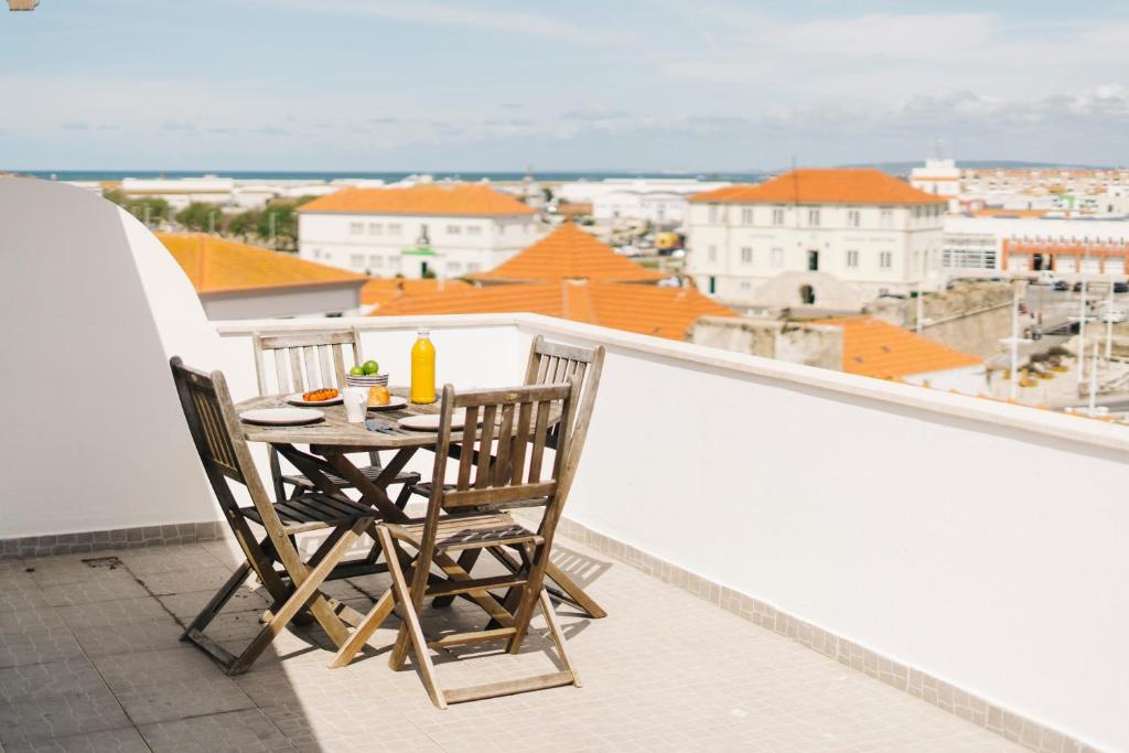 een tafel en stoelen op een balkon met uitzicht bij Best Houses 45 - Beautiful ocean and city view in Peniche