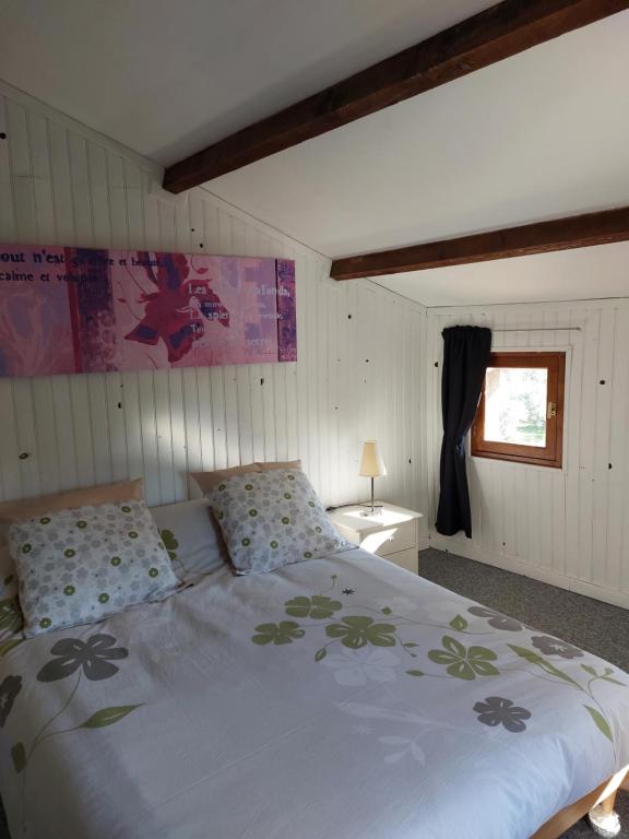 sypialnia z dużym łóżkiem i oknem w obiekcie La Quiétude w mieście Cotignac
