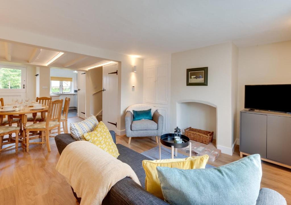 a living room with a couch and a table at Japonica Cottage in Wenhaston