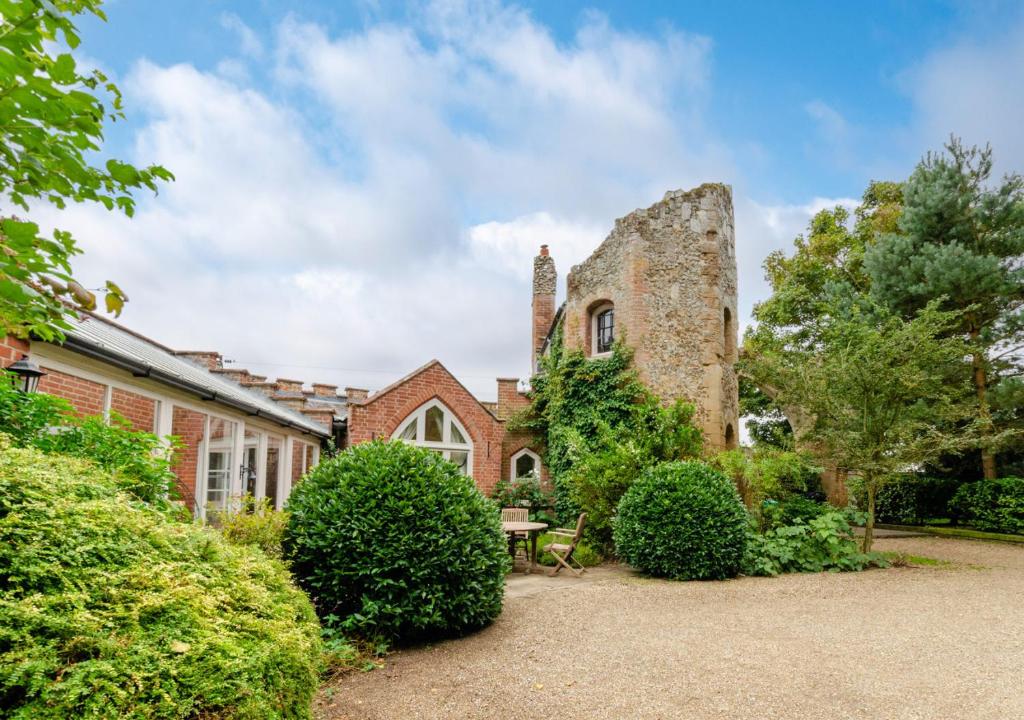 an old stone house with a table in the yard at Ivy Lodge in Rendlesham