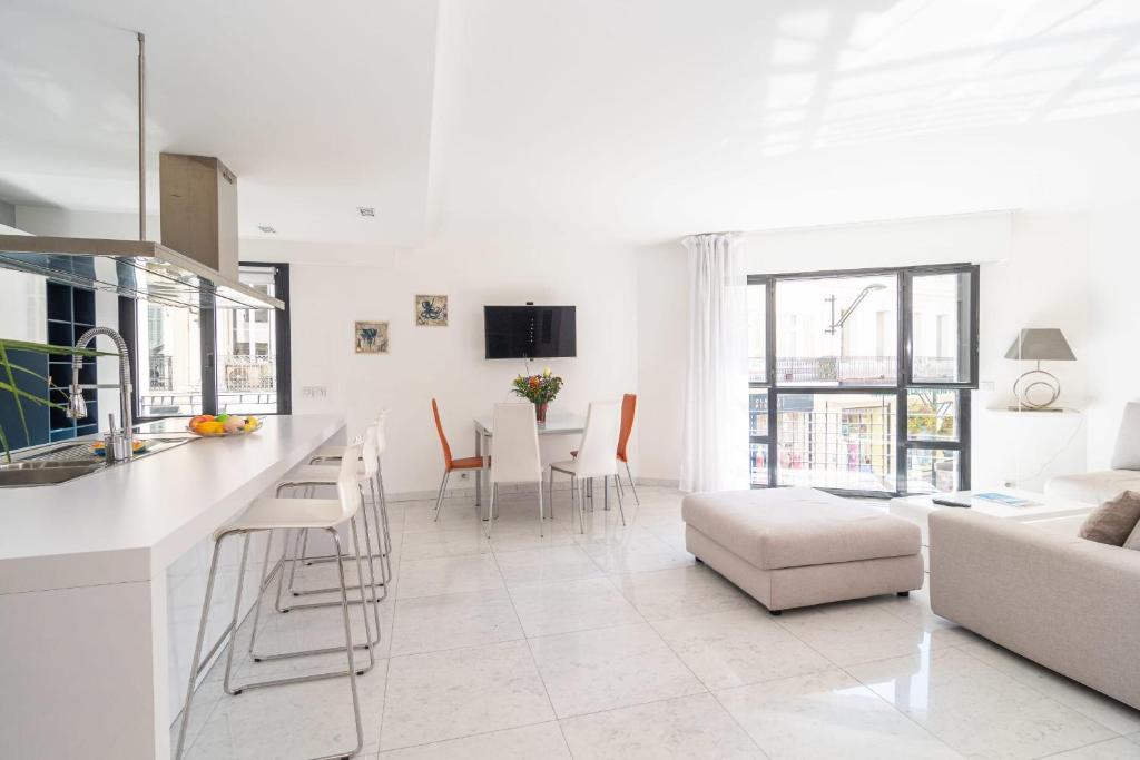 Il dispose d'une cuisine blanche et d'un salon avec une table et des chaises. dans l'établissement Cannes Rue d'Antibes Premium 2 BDR 2 baths Exclusive Olam Properties, à Cannes