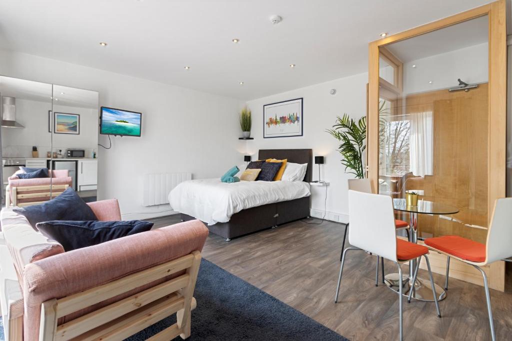 a living room with a bed and a table and chairs at Exeter City Centre Apartments Stoop Apartment in Exeter