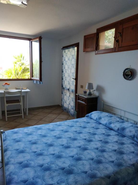 a bedroom with a large blue bed and a table at Casa con vista sul golfo vicina al mare in Santa Luria