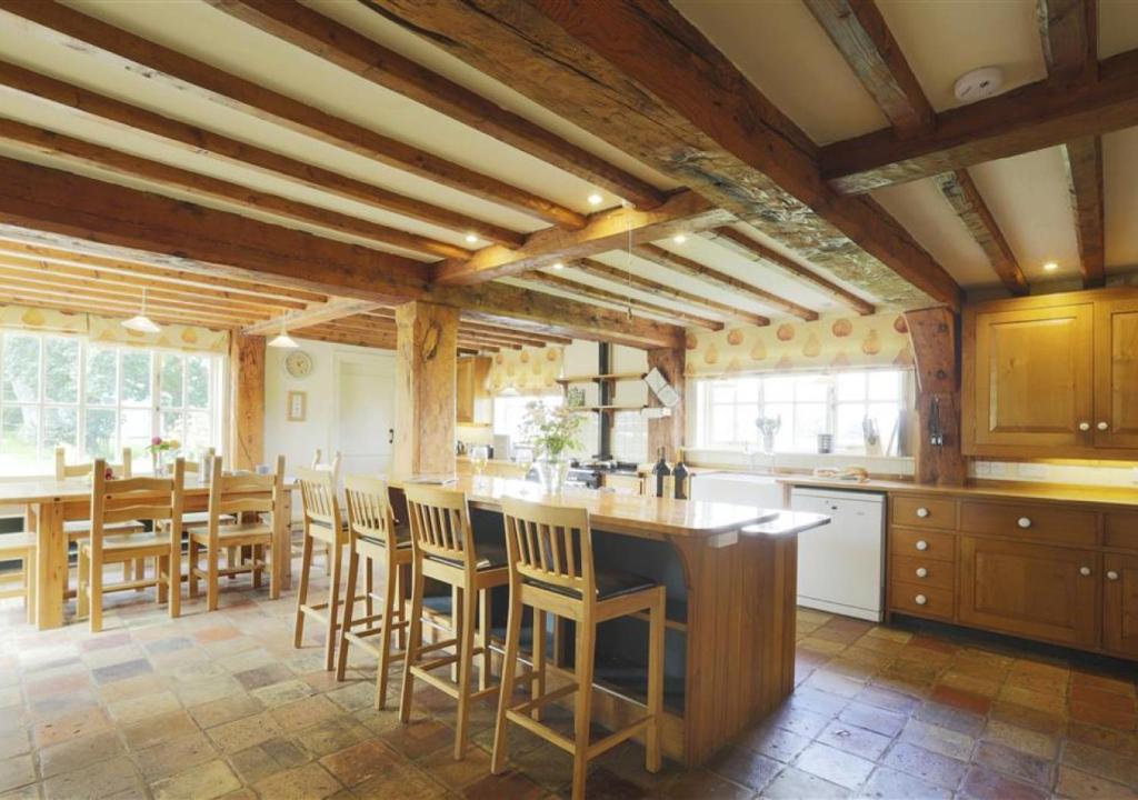 a kitchen with wooden ceilings and a table and chairs at Kings Farm in Wangford