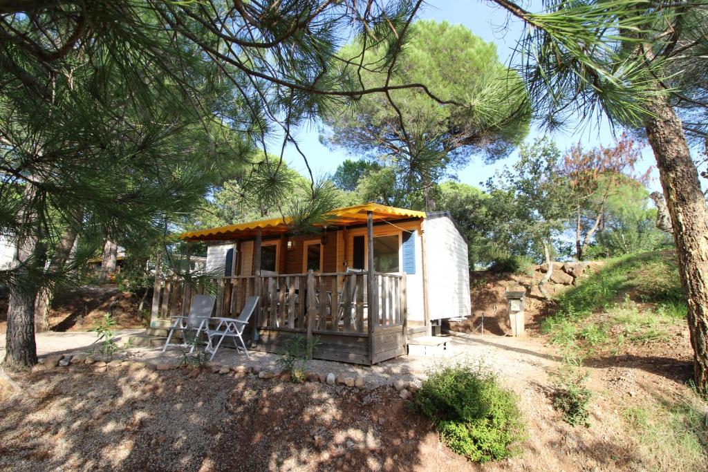 阿爾讓河畔羅科布呂訥的住宿－Harbers zonvakanties chalets met airco camping Leï Suves Roquebrune sur Argens，小屋,设有树林中的门廊