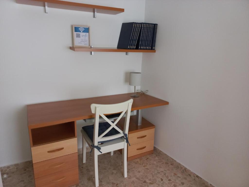 a desk with a chair in a room with a wall at Apartamento Camberos Antequera in Antequera