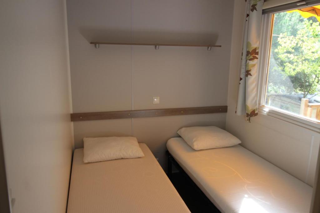 Postel nebo postele na pokoji v ubytování Harbers zonvakanties chalets met airco camping Leï Suves Roquebrune sur Argens