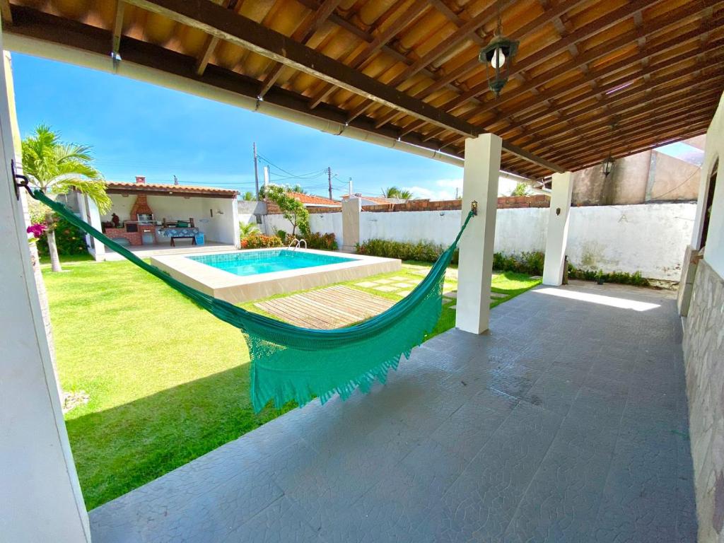 a hammock on the patio of a house at Casa Cantinho de Arembepe - Linda casa com piscina no litoral norte da Bahia in Camaçari