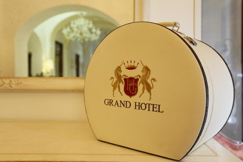 uno specchio con un grande cartello dell'hotel su un bancone di Grand Hotel Di Lecce a Lecce